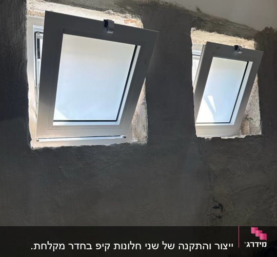 התקנת שני חלונות ציר מאלומיניום לבן בזמן שיפוץ